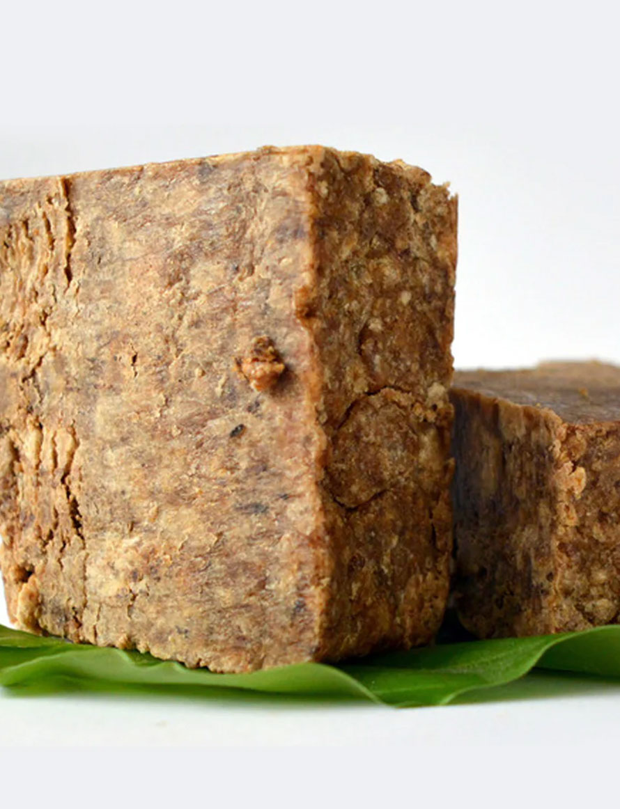 African Black Soap bars on green leaves, highlighting natural skincare benefits and traditional ingredients from West Africa.