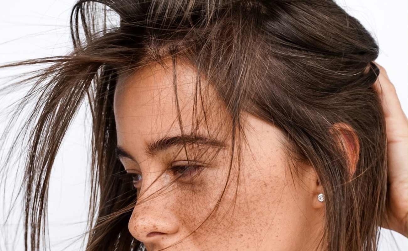 Close-up of a woman showcasing styled hair with curled buns, emphasizing texture and movement, relevant to La Belle African Braids' creative hairstyle portfolio.