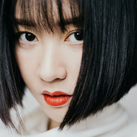 Woman with sleek black bob hairstyle and bold red lipstick, showcasing a casual look for hairstyling inspiration.