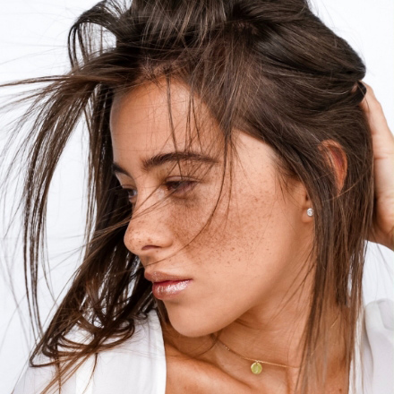 Woman with tousled hair and freckles, showcasing a casual hairstyle, emphasizing a relaxed and stylish look, relevant to La Belle African Braids' portfolio of African braiding styles.